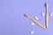 Dental care. Two wooden bamboo eco friendly toothbrushes and chewing gum in the form of hours on a purple background.