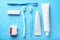 Dental floss, toothbrushes and paste on color background