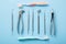 Dental health and teethcare concept. Top view of dental tools set on blue background with toothbrushes in dentists clinic: dental