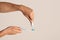 Dental hygiene. Young guy applying paste from tube onto toothbrush against light background, copy space