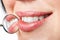 Dental mouth mirror near healthy white woman teeth