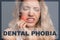 Dental phobia concept. Young woman suffering from toothache on background