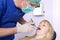 Dental-Surgeon examining the teeth of a woman.