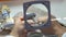 Dental technician grinds the metal frame through a magnifying glass