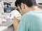 Dental technician modelling an implant ceramic tooth with a drill