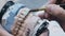 A dental technician paints a denture with a brush.