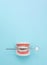 Dental Teeth Model dentures with dentist mouth mirror on blue background. Dental concept. False teeth, jaws. Dentistry conceptual