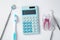 Dental tools with blue calculator and tooth on white background
