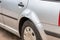 Dented car wing and fender with scratches and bumps after crash and car accident with hit-and-run driving and absconding shows nee