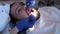 Dentist is applying blue gel on man teeth to find dental tartar and caries closeup. Hygiene care for oral cavity