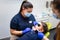 Dentist and assistant make preventive dental plaque cleaning for teenager.