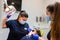 Dentist and assistant make preventive dental plaque cleaning for teenager.