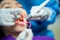 Dentist with an assistant in protective gloves are examining her teeth with a help of a dental bur with a mirror and an air