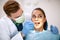 Dentist checking up girlâ€™s teeth with mirror