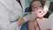 Dentist in the dental office, Woman Dentist Treating Teeth to little girl child Patient in Clinic. Female Professional