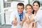 Dentist doctor, assistant and little girl all smiling at camera