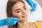 A dentist doctor treats caries on a tooth of a young beautiful woman in a dental clinic. Tooth filling