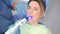 Dentist doctor using dental curing light equipment for filling, examining a patient`s teeth in dentistry office