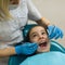 Dentist doing teeth checkup of little girl at medical clinic.