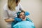 Dentist doing teeth checkup of little girl in a stomatology chair at clinic