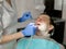 Dentist is doing treatment procedures in dental office.
