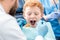 Dentist examinating boy`s teeth