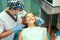 Dentist examine female patient with braces in denal office.