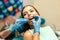 Dentist examine female patient with braces in denal office.