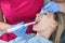 A dentist examines a patient, close-up of a patient with an open mouth next to which dental objects