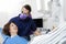 Dentist Examining Happy Female Patient In Clinic