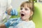 Dentist examining little girl`s teeth in clinic. Dental problem.