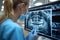 Dentist examining X-rays with modern equipment in a well-lit dental clinic