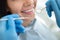 Dentist examining teeth of young happy woman, close-up shot