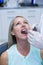 Dentist examining a woman with tools