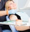 Dentist explaing dental treatment with denture to female patient