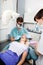 Dentist And Female Assistant Treating A Patient At