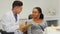 Dentist filling medical papers of his female patient