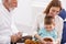 Dentist fixing tooth to a little boy sitting in mother\'s lap