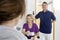 Dentist Giving Medicine To Patient While Sitting By Colleague