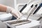 Dentist with gloved hand is picking dental tool in dental office