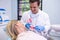 Dentist holding dental mould by woman at clinic