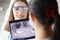 Dentist holding digital tablet with panoramic shot of jaw in front of female patient in clinic