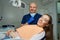 Dentist lowered the medical face mask near smiling patient in a dentist`s office