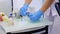 Dentist nurse is taking tools from metal tray on glass table, hands closeup.