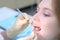 Dentist orthodontist examines girl`s teeth using dental tools needle and mirror.