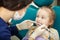 Dentist polishes childs teeth with modern electric tool