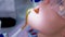 Dentist pours water on woman teeth use saliva ejector during cure, closeup view.