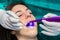 Dentist preventing tooth decay with led curing light on girl.