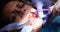 Dentist removes tooth enamel before installing ceramic dental veneers