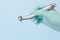 Dentist`s hand in glove with dental handpiece